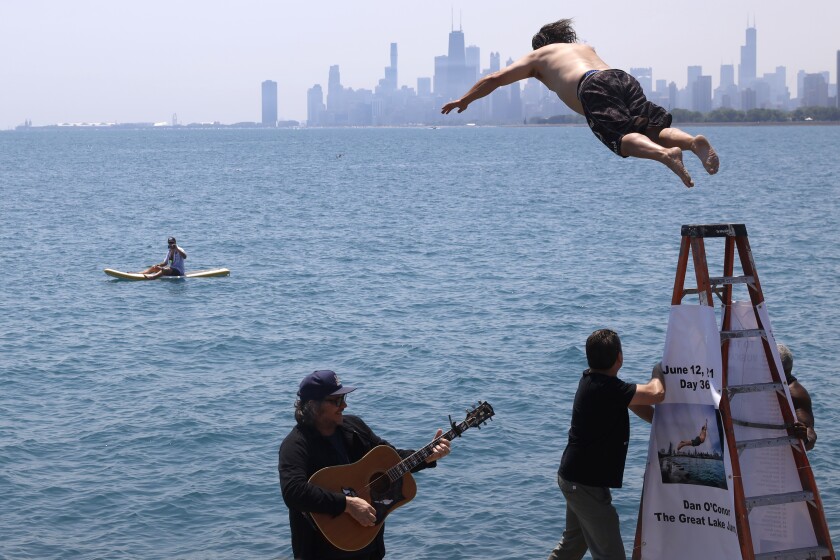 Dan O'Conor, the "Great Lake Jumper," makes his 365th leap into Lake Michigan, Saturday, June 12, 2021, in Chicago's Montrose Point. (AP Photo/Shafkat Anowar)