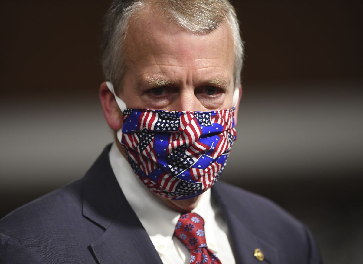 FILE - In this May 7, 2020, file photo, Sen, Dan Sullivan, R-Ark., wears a mask at a hearing in Washington. Protesters in Alaska carrying a banner and a caribou heart interrupted a campaign event for Sullivan who is seeking reelection. The Anchorage Daily News reported the small group of protesters were restrained and escorted out by staff and attendees at Sullivan's campaign launch event in a hangar near Ted Stevens Anchorage International Airport, Saturday, July 11. (Kevin Dietsch/Pool via AP, File)