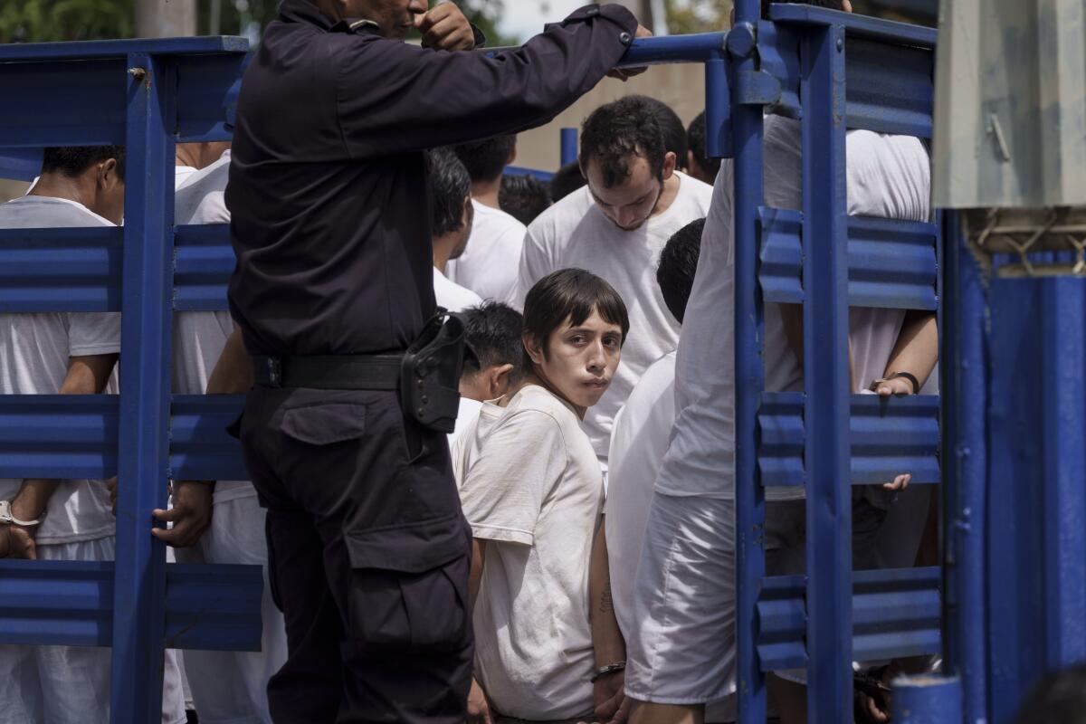 Men detained under a state of emergency arrive in a cargo truck at a detention center.