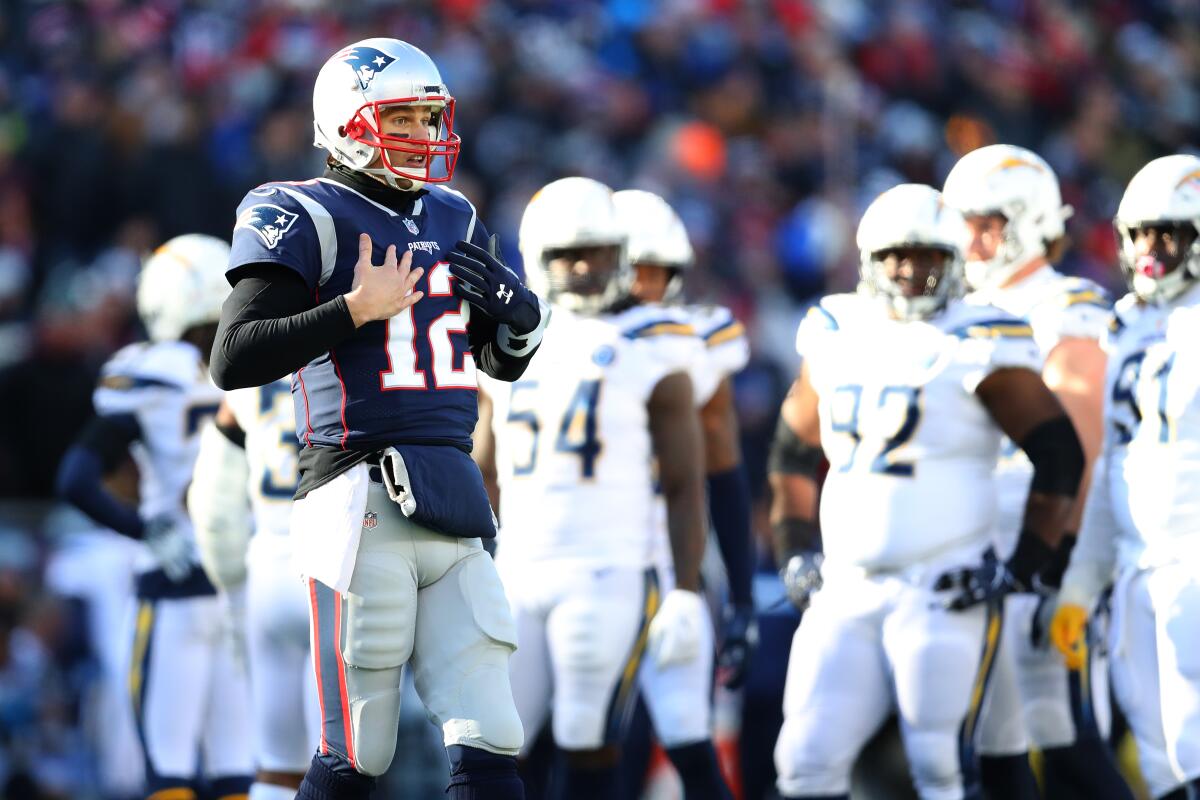 Tom Brady gestures toward the sideline during a playoff game against the Chargers.