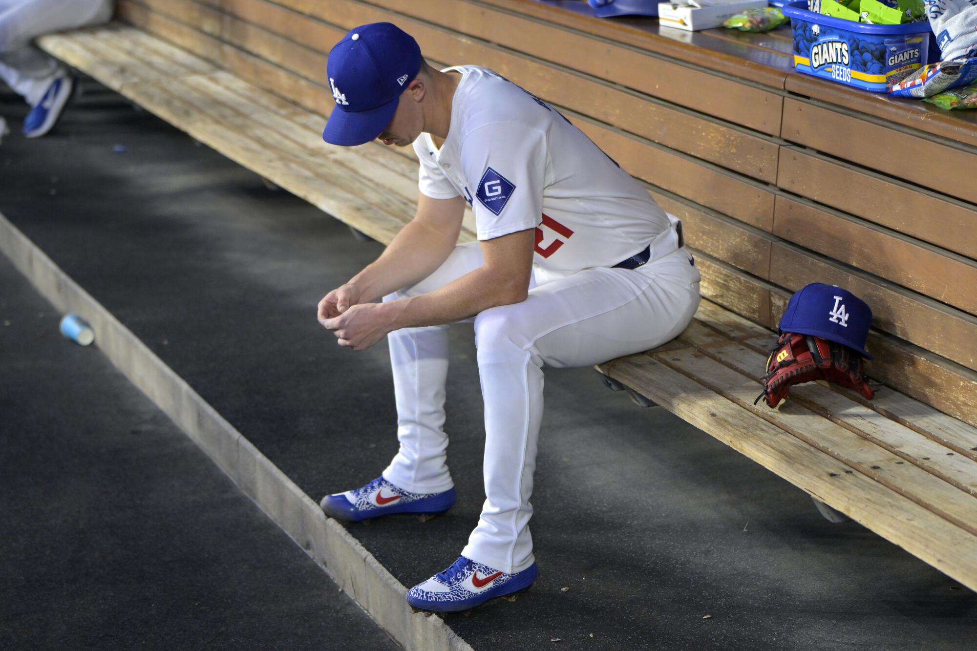 Dodgers' Walker Buehler sits in the dugout after the first inning of a game against the Seattle Mariners