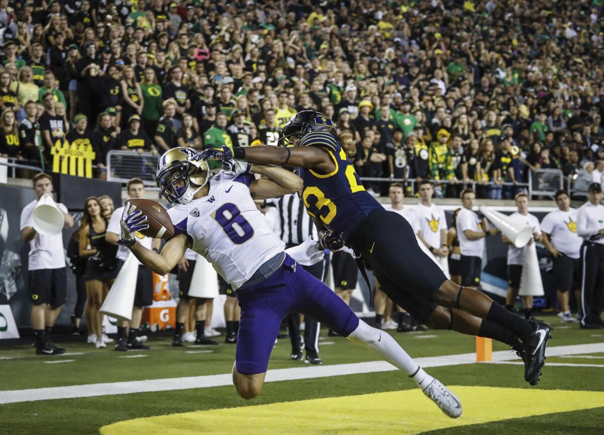 Washington wide receiver Dante Pettis (8) catches a one-handed pass with pressure from Oregon defensive back Malik Lovette (23), who was called for pass interference on the play.