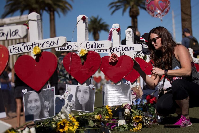 LAS VEGAS, NV - OCTOBER 6: Randi Coe writes a note on a cross for Carly Kreibaum, who was killed in Sunday night's mass shooting, at a makeshift memorial on the south end of the Las Vegas Strip, October 6, 2017 in Las Vegas, Nevada. On October 1, Stephen Paddock opened fire on the crowd killing at least 58 people and injuring more than 450. The massacre is one of the deadliest mass shooting events in U.S. history. (Photo by Drew Angerer/Getty Images) ** OUTS - ELSENT, FPG, CM - OUTS * NM, PH, VA if sourced by CT, LA or MoD **