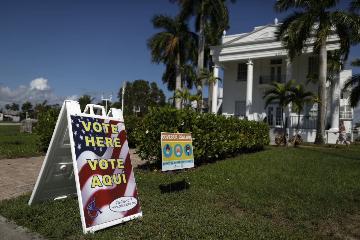 A man walks into City Hall, with a "Vote Here" outside, in Everglades City, Fla.