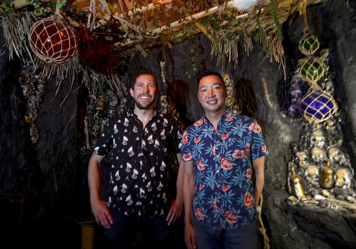 Owners Dominic Iapello and Leonard Chan, from left, stand at the new Stowaway Tiki Bar, which has reopened in Tustin.