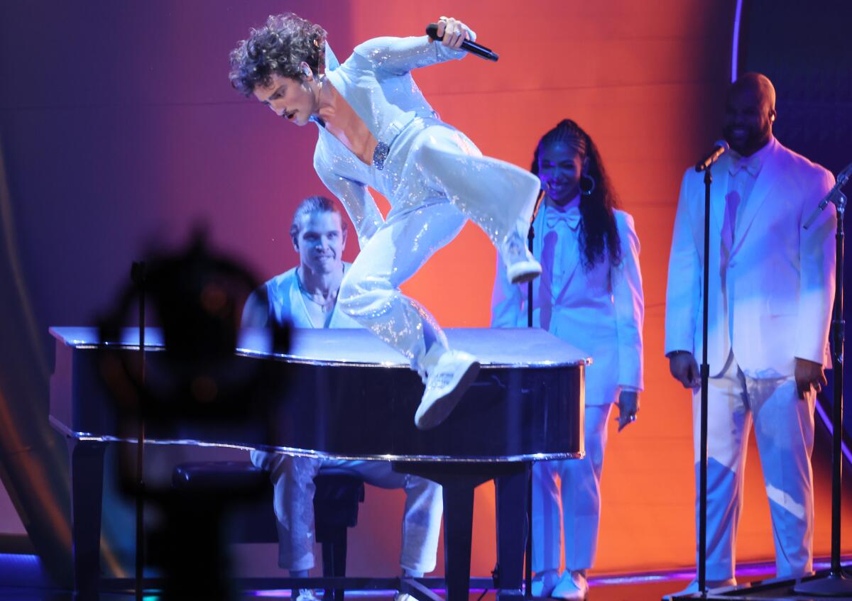 Benson Boone jumps off a grand piano.