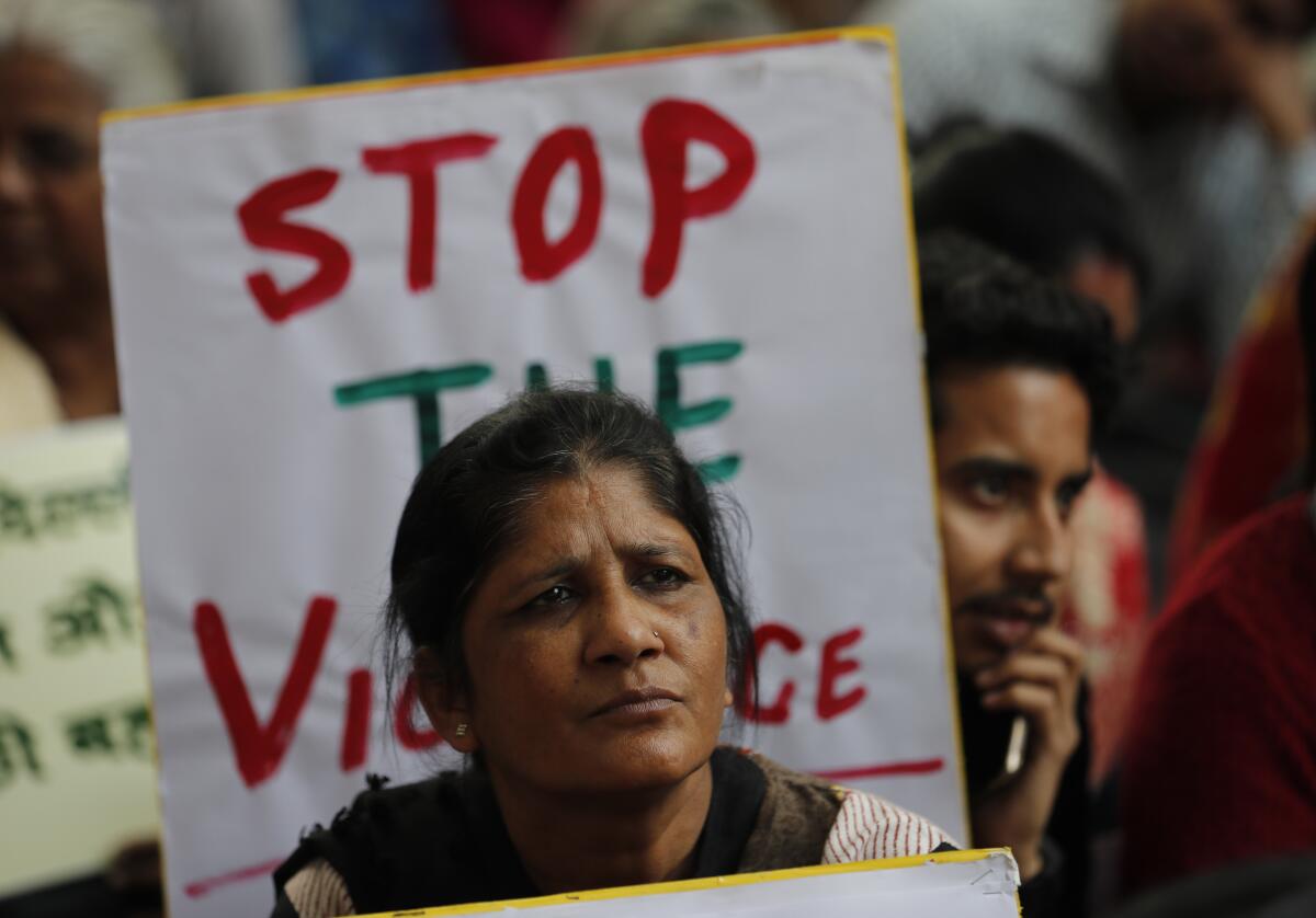 Activists hold banners calling for peace following violence Feb. 26 in New Delhi.