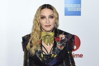 Madonna in a black blazer with metallic detailing posing at a red carpet