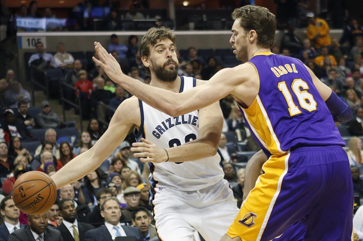 Grizzlies center Marc Gasol tries to pass around his brother, Lakers forward Pau Gasol. While the Grizzlies are still alive in the playoff race, the Lakers have been eliminated.