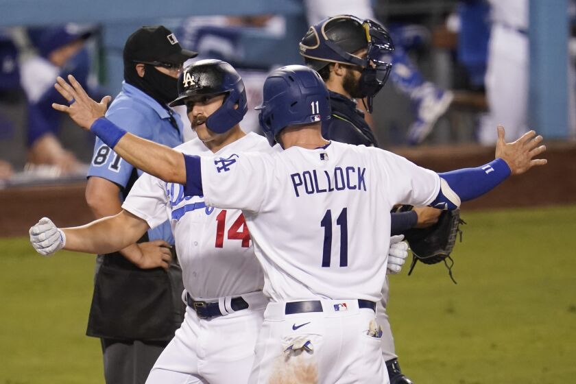 Los Angeles Dodgers' Enrique Hernandez, left, celebrates his two-run home run with A.J. Pollock (11) during the seventh inning of a baseball game against the Seattle Mariners Monday, Aug. 17, 2020, in Los Angeles. (AP Photo/Marcio Jose Sanchez)