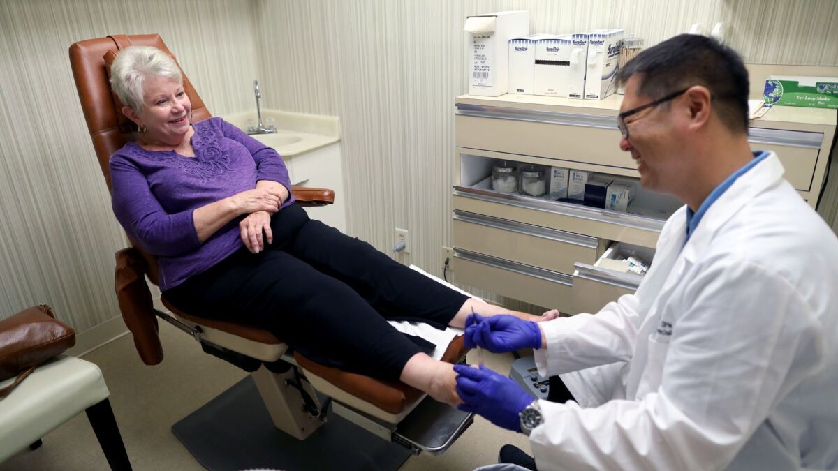 Carol Richards, 78, left, of Los Angeles has a foot procedure done by Dr. Thomas Lim at Sunset Foot Clinic in Los Angeles.