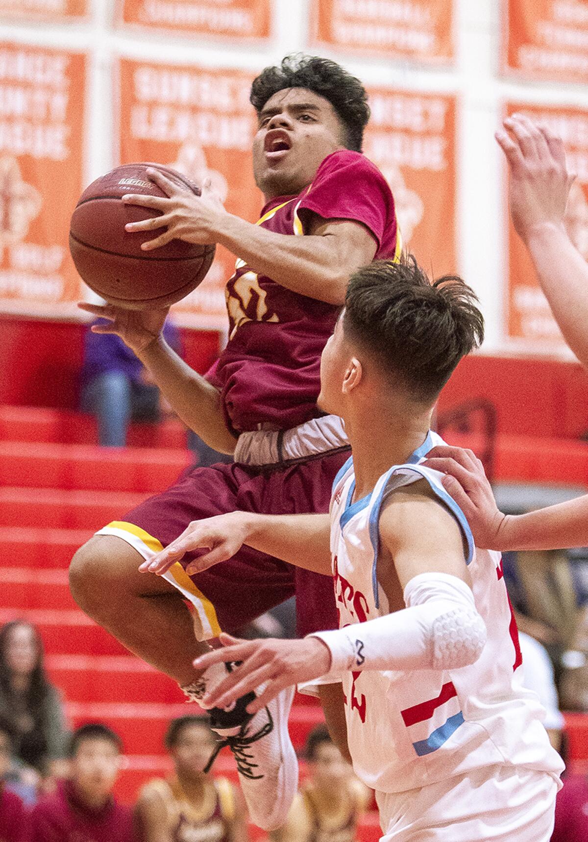 Estancia's Marvin Harry goes up for a shot against Santa Ana's Xavier Valdovinos during an Orange Coast League game on the road Wednesday.