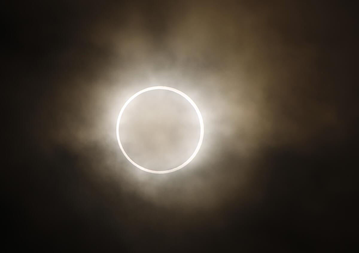 A bright ring resembles a fiery circle in the sky surrounded by haze.