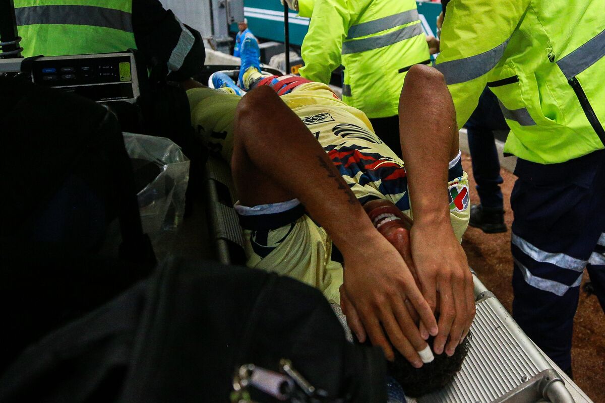 Club America's Giovani Dos Santos is carted off the field during a game against Guadalajara on Sept. 28 in Mexico City.