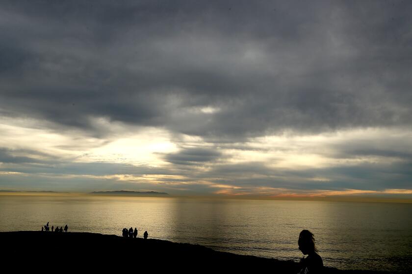 SAN PEDRO, CALIF. - DEC. 26, 2022. Vistors to Angels Gate Park in San Pedro walk under cloudy skies on Monday, Dec. 26, 2022. Weather forecasters say recent sunny weather will give way to rain by midweek. (Luis Sinco / Los Angeles Times)