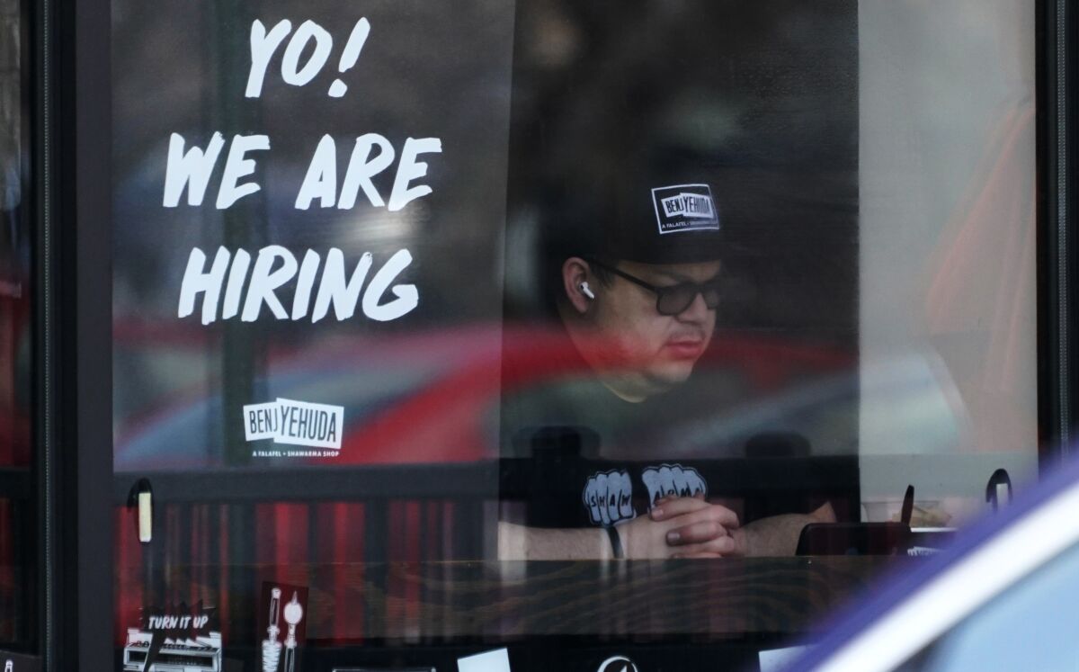 A hiring sign is displayed at a restaurant in Schaumburg, Ill., Friday, April 1, 2022. Fewer Americans applied for unemployment benefits last week as layoffs remain at historically low levels. Jobless claims fell by 5,000 to 166,000 for the week ending April 2, the Labor Department reported Thursday. (AP Photo/Nam Y. Huh)