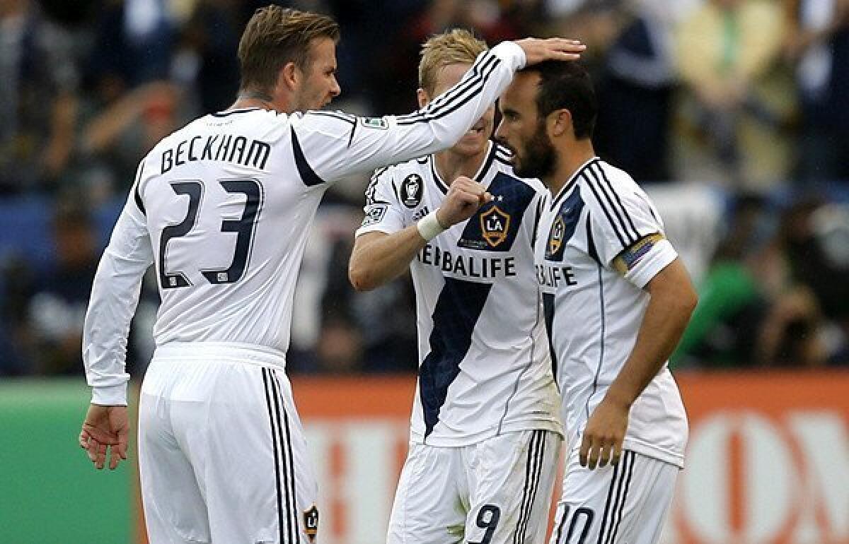 Galaxy forward Landon Donovan (10) is congratulated by midfielders David Beckham and Christian Wilhelmsson (9) after scoring on a penalty kick against the Dynamo in the second half Saturday.