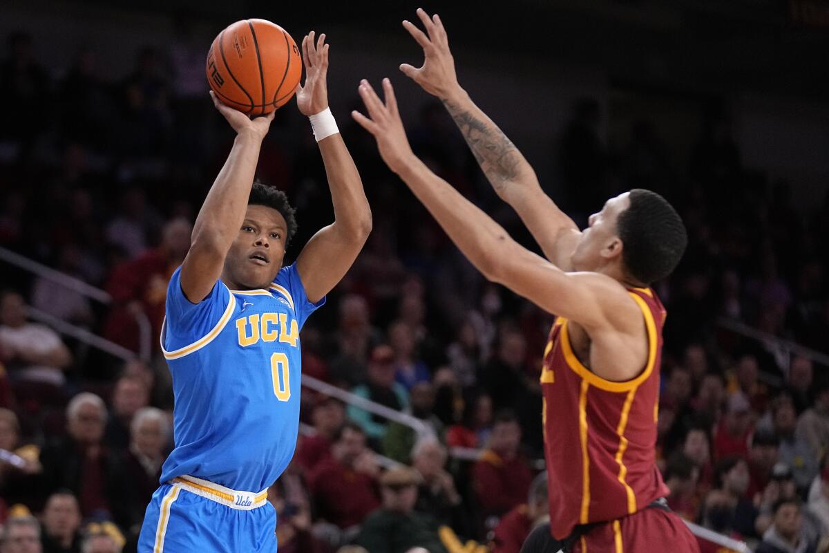 UCLA guard Jaylen Clark, left, shoots as USC forward Kobe Johnson defends during the first half Thursday.