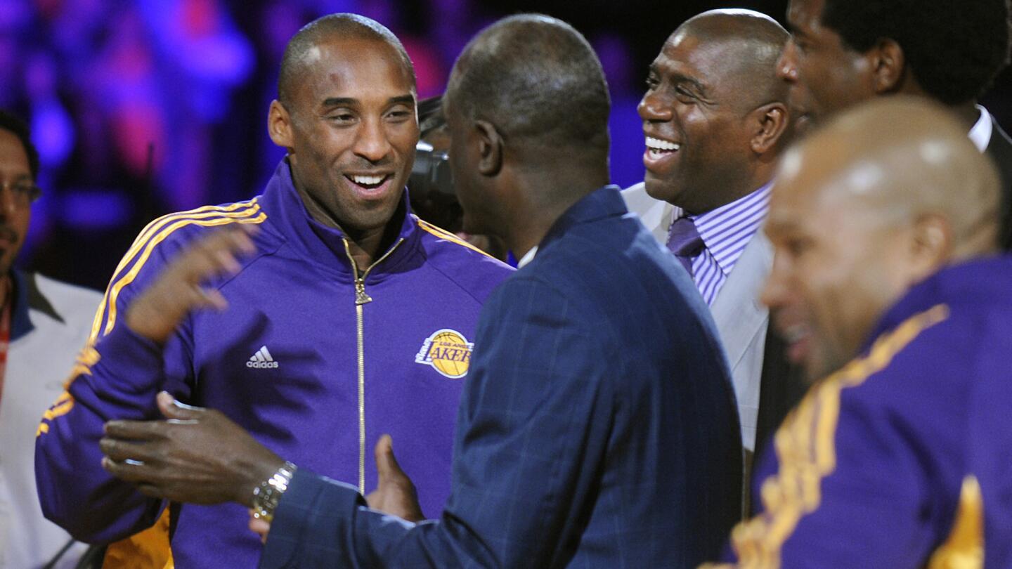 Lakers star Kobe Bryant is greeted by former Lakers Michael Cooper, center, Magic Johnson, second right, and A.C. Green after receiving his 2009 NBA championship ring at Staples Center on Oct. 27, 2009.