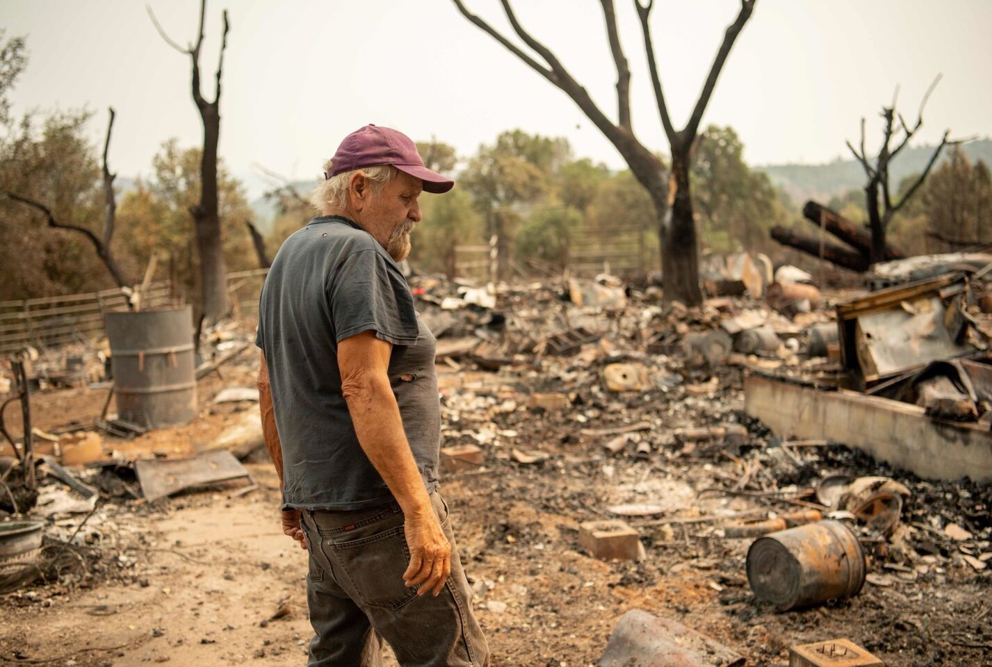 Arnold Lasker looks over the remains of his girlfriend's house in Spring Valley, near Clearlake Oaks, on Aug. 7.