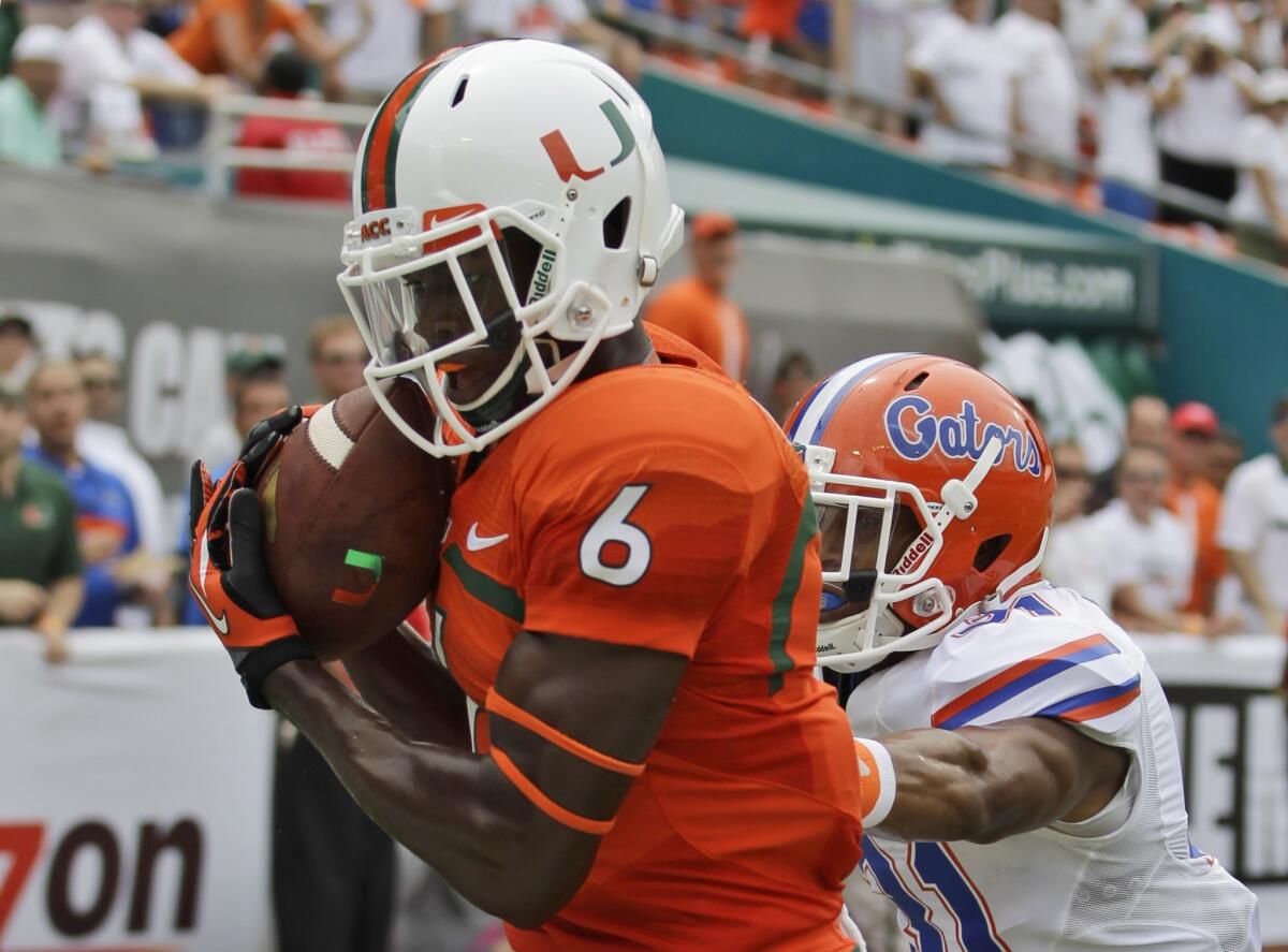 Miami receiver Herb Waters hauls in a touchdown reception against Florida defensive back Cody Riggs in the first half Saturday.