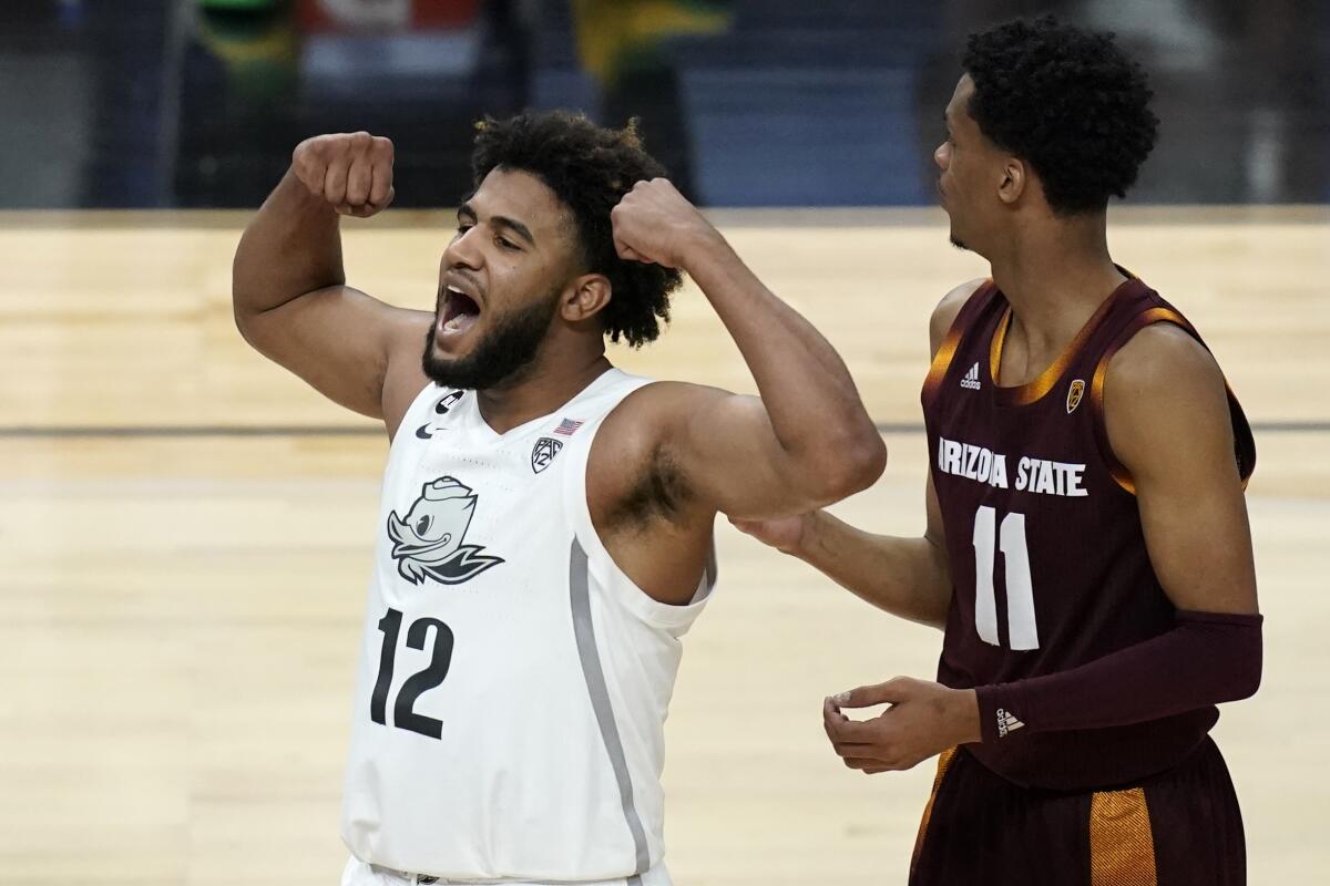Oregon's LJ Figueroa (12) celebrates after a play against Arizona State during the second half of an NCAA college basketball game in the quarterfinal round of the Pac-12 men's tournament Thursday, March 11, 2021, in Las Vegas. (AP Photo/John Locher)