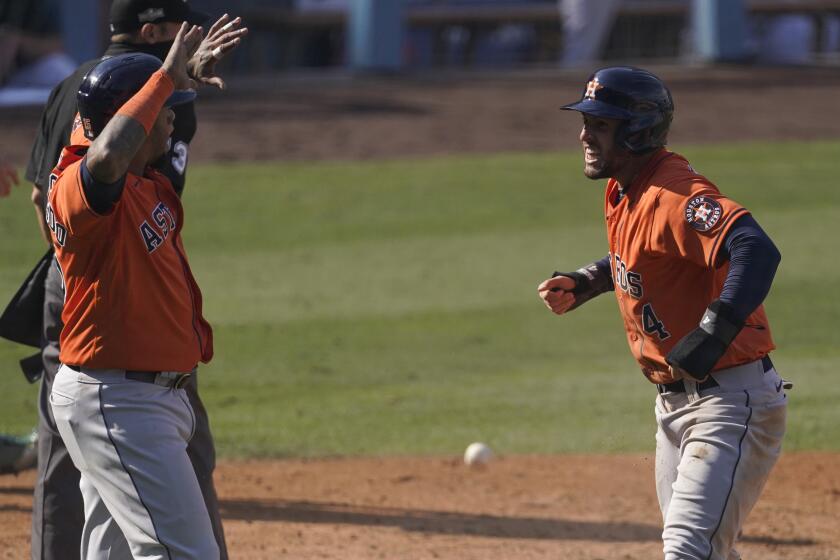 Houston Astros' George Springer, right, celebrates with Martin Maldonado after they scored on a single by Jose Altuve during the sixth inning of Game 1 of a baseball American League Division Series against the Oakland Athletics in Los Angeles, Monday, Oct. 5, 2020. (AP Photo/Ashley Landis)