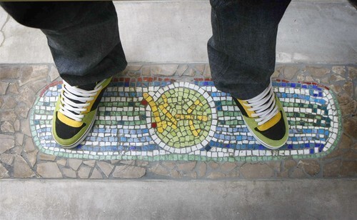 Pierre Andre Senizergues takes a familiar stance on a patio mosaic.