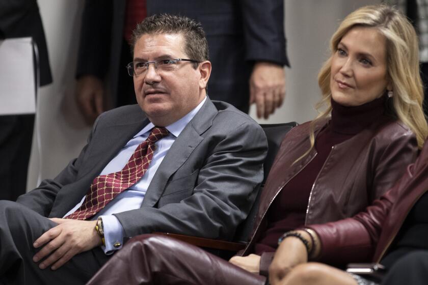 Washington Commanders owner Dan Snyder and his wife Tanya Snyder, listen to head coach Ron Rivera during a news conference