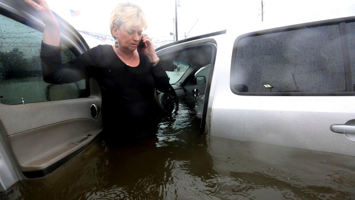 Rhonda Worthington talks on her cellphone with a 911 dispatcher after her car became stuck in rising floodwaters from Tropical Storm Harvey in Houston. Worthington said she thought the water was low enough to drive through before the vehicle started to float away.