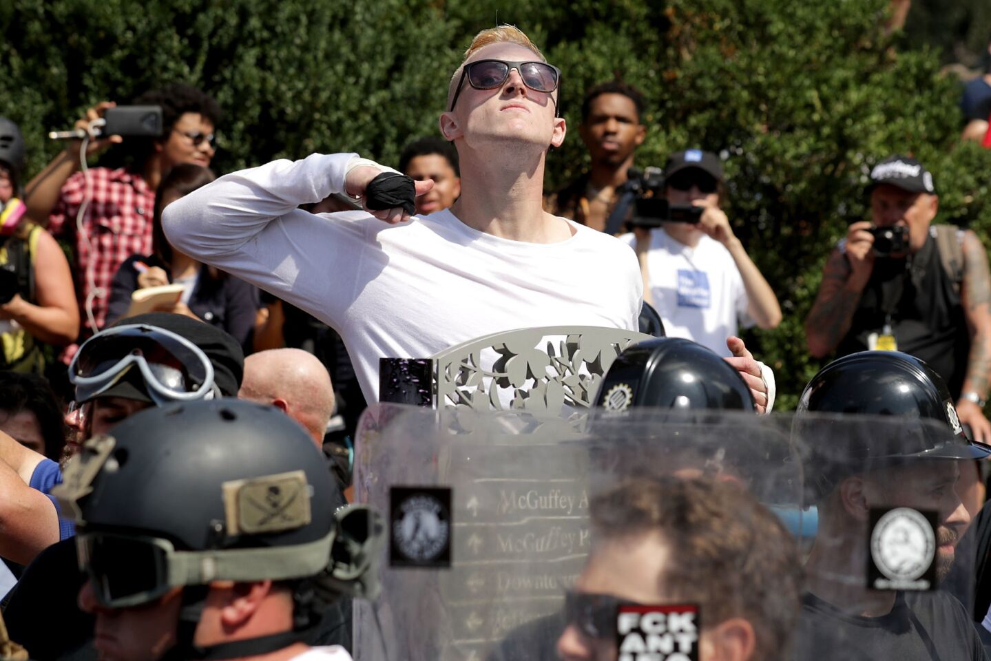 A man makes a slashing motion across his throat toward counter-protesters while marching with other white nationalists, neo-Nazis and members of the "alt-right" during a rally in Charlottesville, Va.