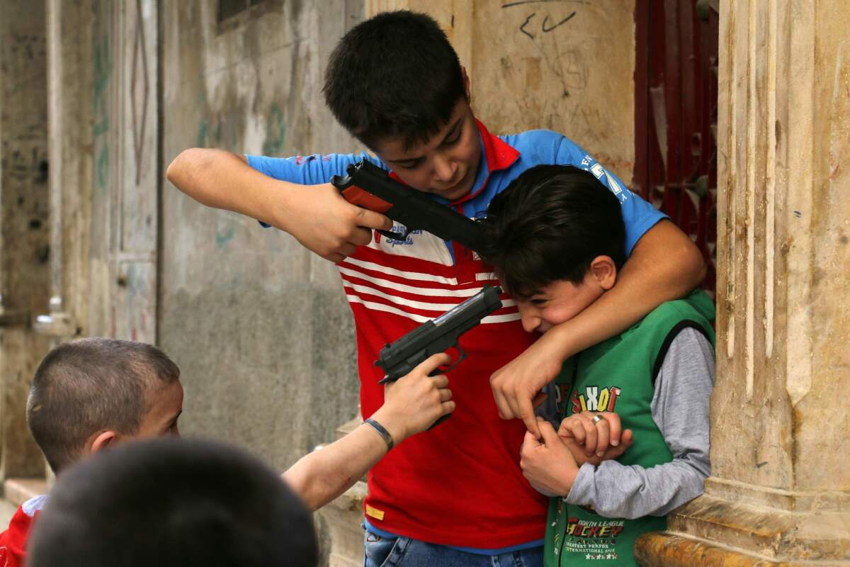 Syrian children play on a street with plastic toy guns in a rebel-held district of the northern city of Aleppo on July 6, 2016, during celebrations for Eid al-Fitr, which marks the end of the Muslim holy fasting month of Ramadan.