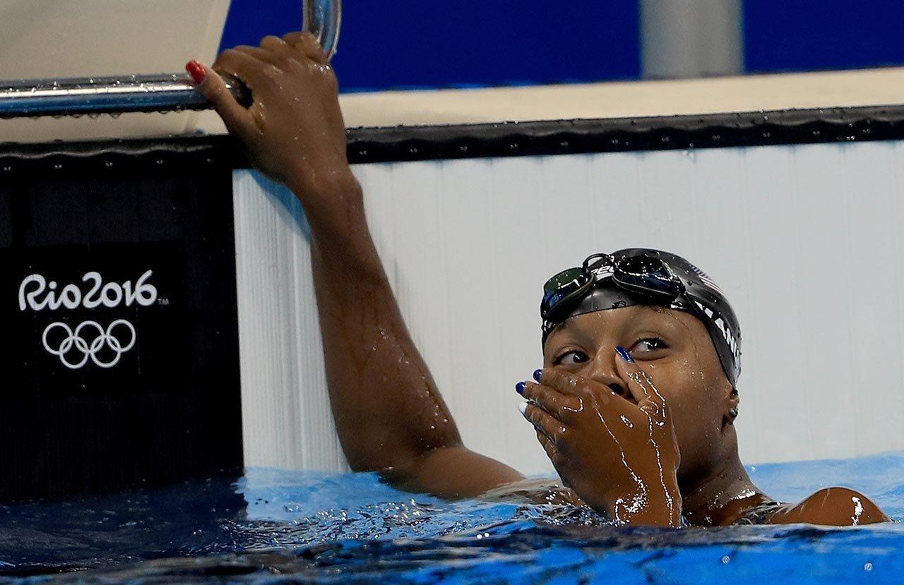 Simone Manuel of the United States looks at the clock and sees hergold-winning time iin the Women's 100m Freestyle Final on Day 6 of the Rio 2016 Olympic Games at the Olympic Aquatics Stadium.