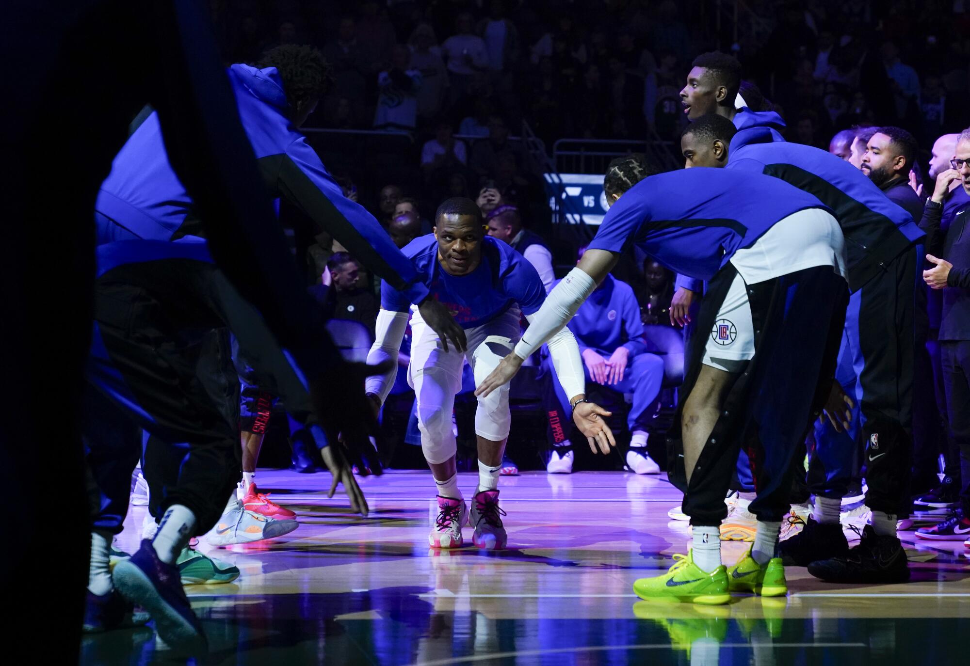 Les Clippers gardent les coéquipiers de Russell Westbrook en low-five lors des présentations avant un match préparatoire contre l'Utah.