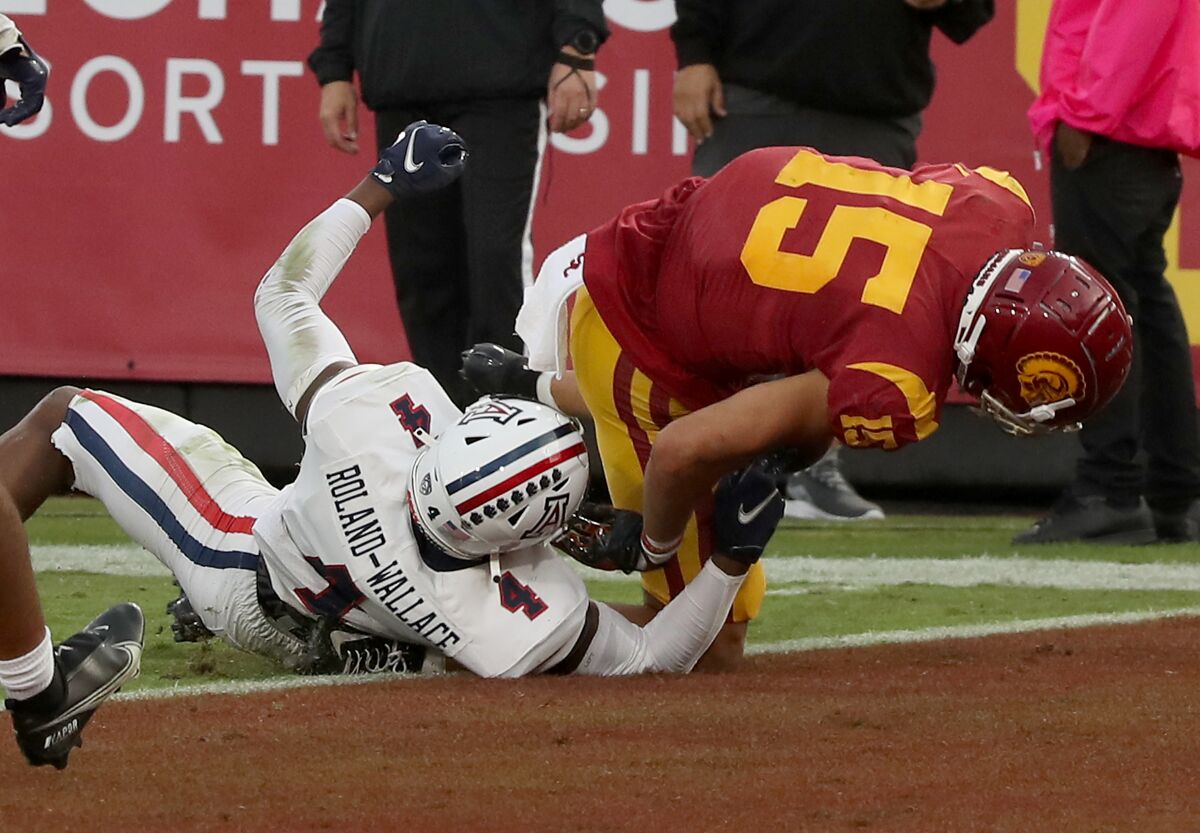 USC's Drake London gets his ankle caught under Arizona cornerback Christian Roland-Wallace while scoring Oct. 30, 2021. 