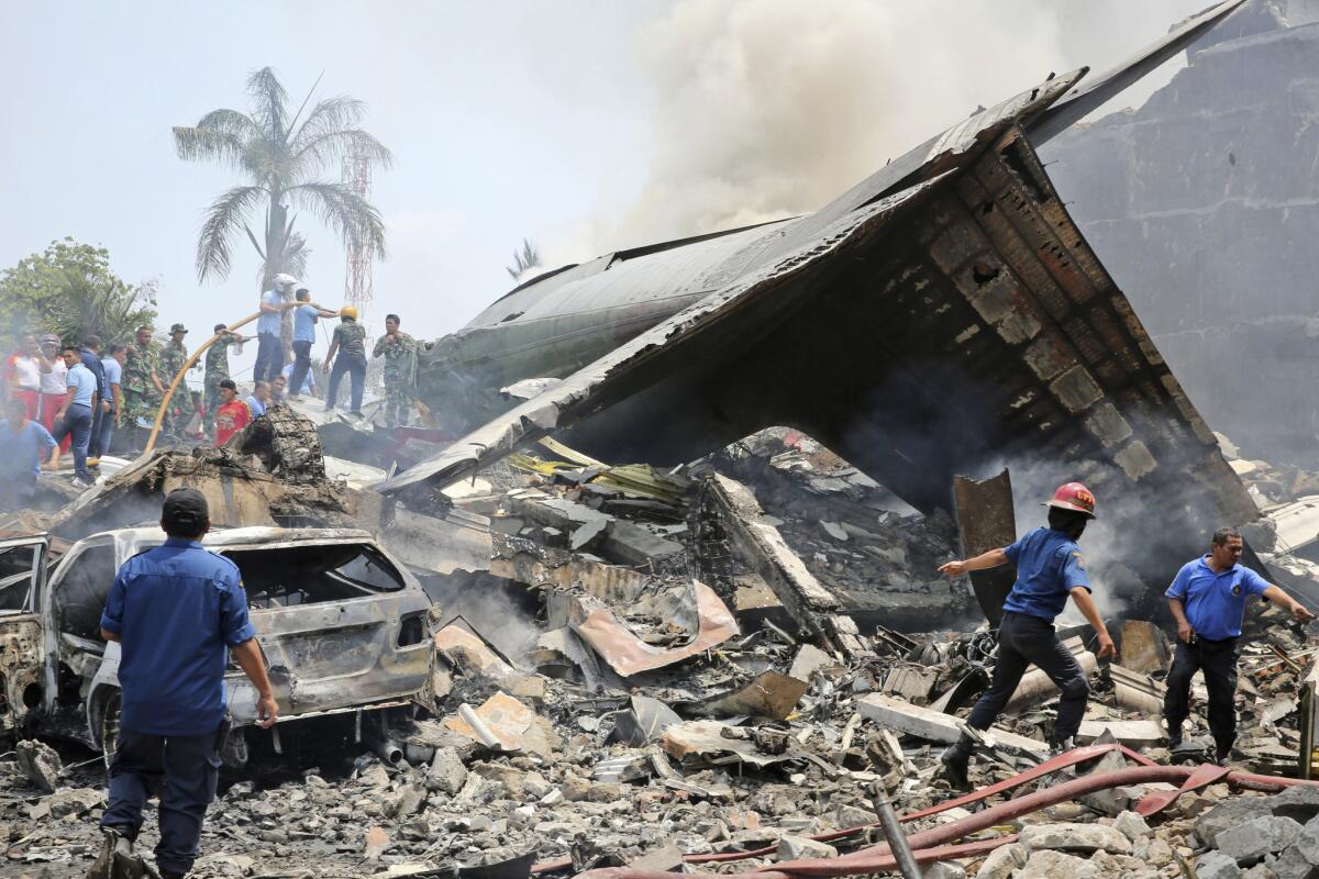 Indonesian military personnel search for victims after an air force cargo plane crashed in Medan on June 30.