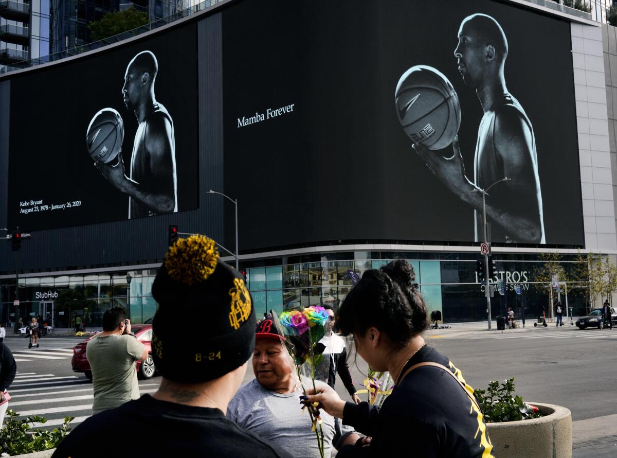 A vendor sells flowers to Kobe Bryant fans in front of a giant electronic billboard featuring the former NBA star near Staples Center in downtown Los Angeles on Jan. 30.