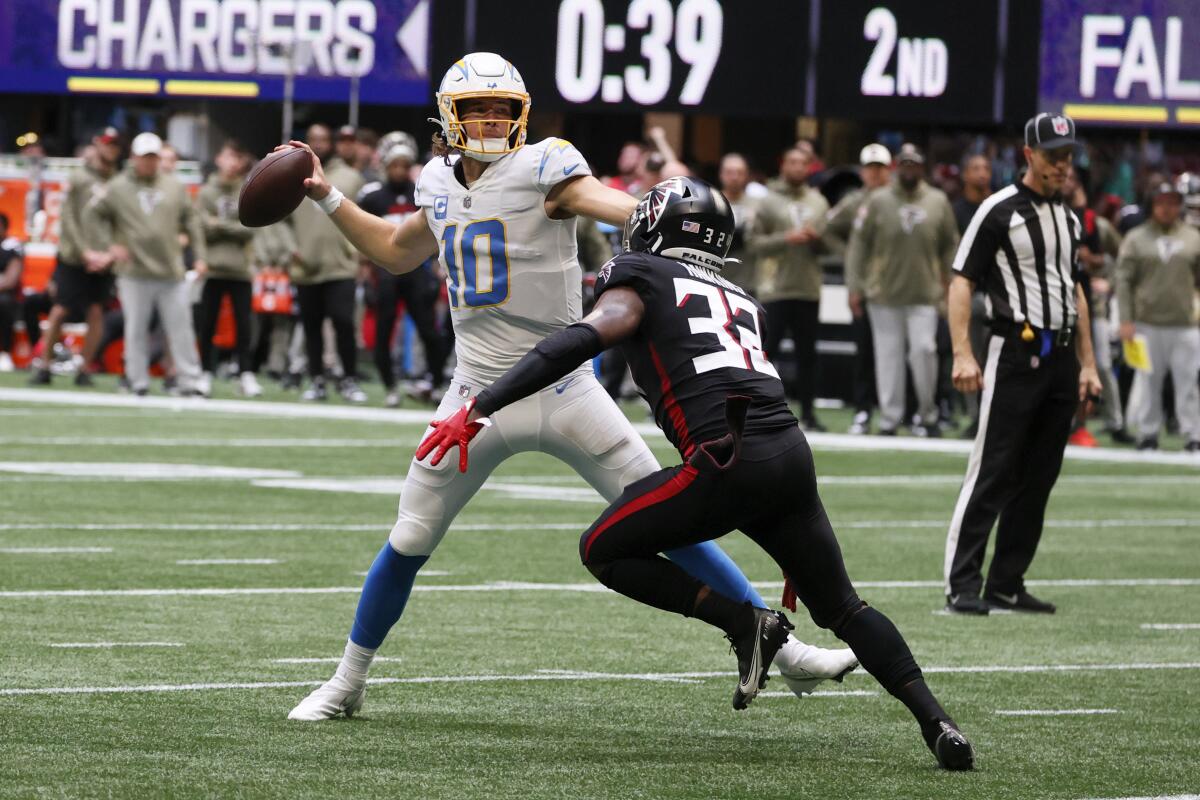 Chargers quarterback Justin Herbert (10) throws a pass over Atlanta Falcons safety Jaylinn Hawkins.