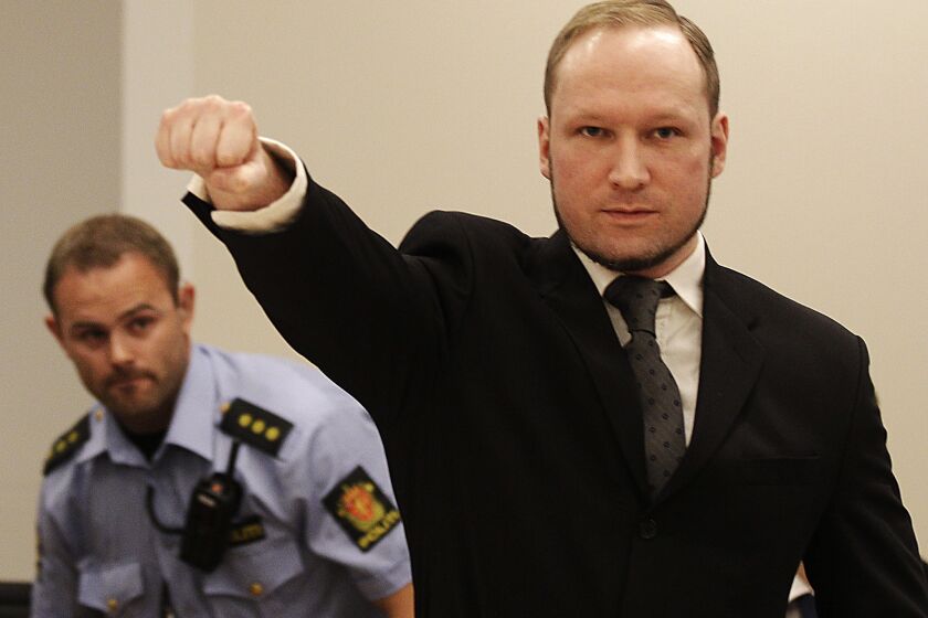 In this Aug. 24, 2012, photo, mass murderer Anders Behring Breivik gives a salute after arriving in a courtroom in Oslo.