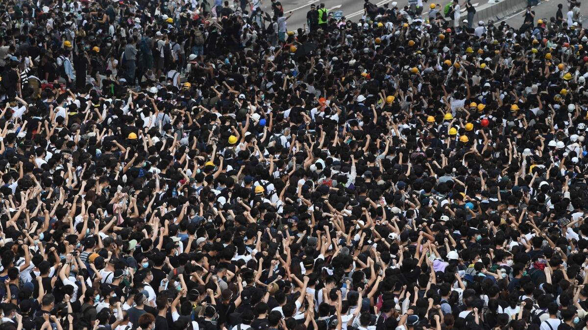 Protesters react after police fire tear gas June 12 during a rally against a proposed extradition law in Hong Kong.
