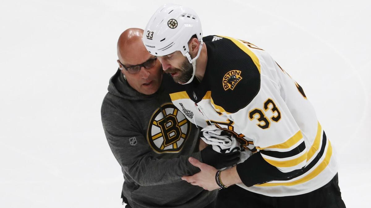 Boston Bruins defenseman Zdeno Chara is helped off the ice after reportedly suffering a broken jaw during Game 4 of the Stanley Cup Final against the St. Louis Blues on Monday.