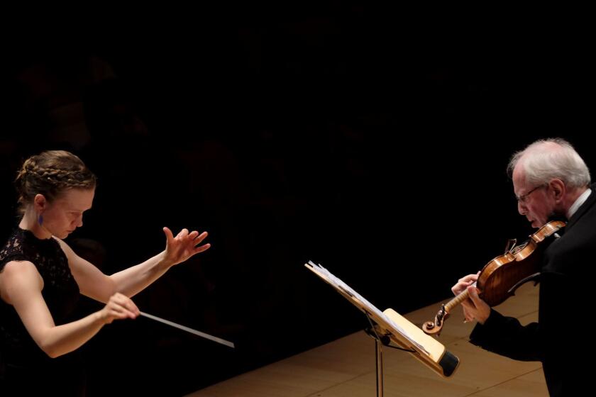 LOS ANGELES, CA October 19, 2017: Mirga Grazinyte-Tyla, left, conducts the LA Phil and Gidon Kremer as soloist, right, at Walt Disney Concert Hall in Los Angeles, CA October 19, 2017. (Francine Orr/ Los Angeles Times)