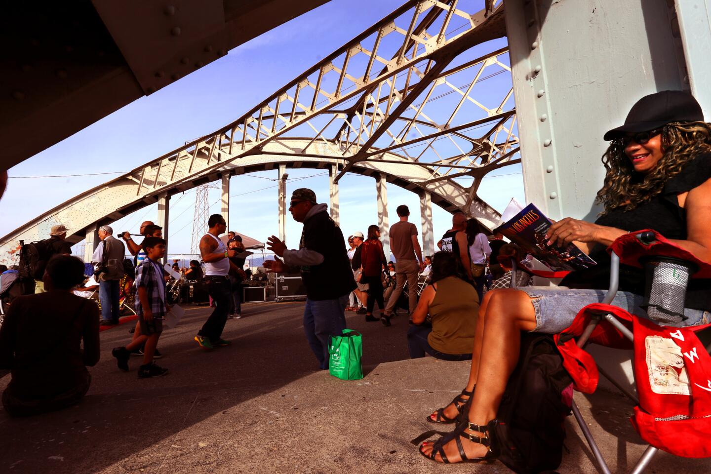 Carmen Pulido, right, reclines as others enjoy their time during the 6th Street Bridge Farewell Festival on Saturday. Bands, food trucks, live mural paintings and fireworks were featured. The iconic span has dramatically deteriorated over the decades largely because of a rare chemical reaction in the concrete supports.