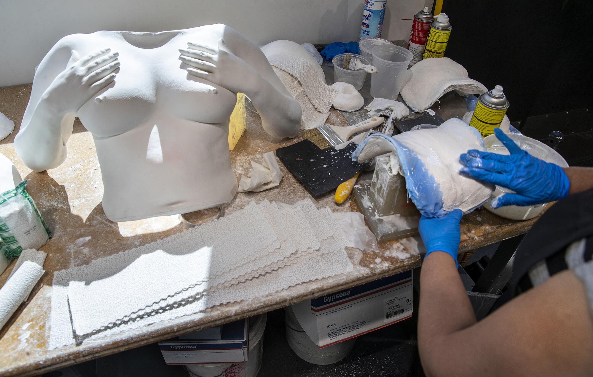 A mold of female genitalia is formed by an employee at Doc Johnson headquarters