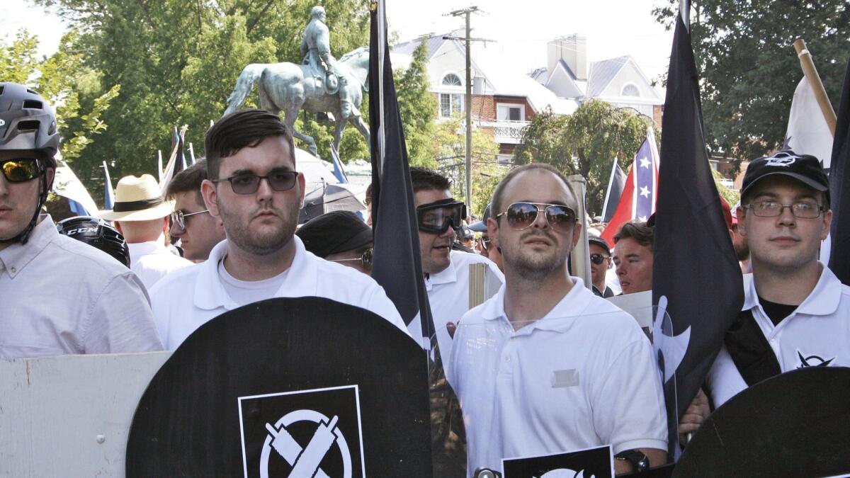 James Alex Fields Jr., second from left, with a shield bearing the logo of the white supremacist group Vanguard America during a rally in Charlottesville, Va., on Aug. 12, 2017.