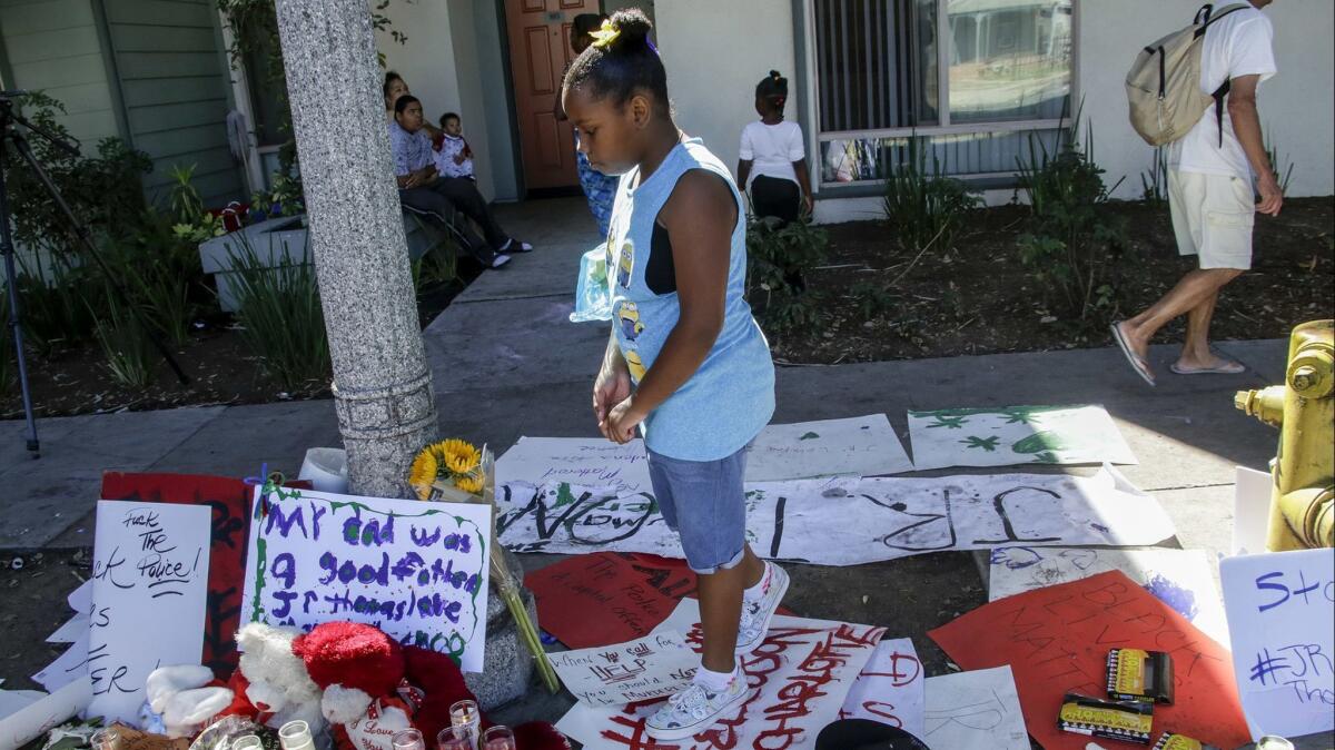 Raquel Thomas, then 9, pays her respects in 2016 at a makeshift memorial for her father, Reginald Thomas Jr.