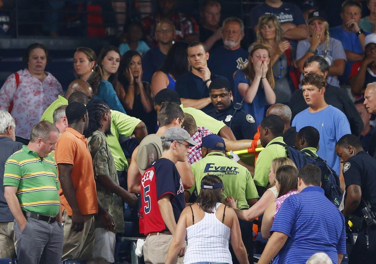 A fan who fell from an upper deck to the lower level is taken from the stadium on a stretcher by rescue personnel during a game between the Braves and Yankees at Turner Field on Saturday night.
