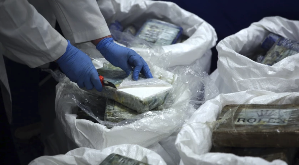 Un oficial abre un paquete con cocaína decomisada.