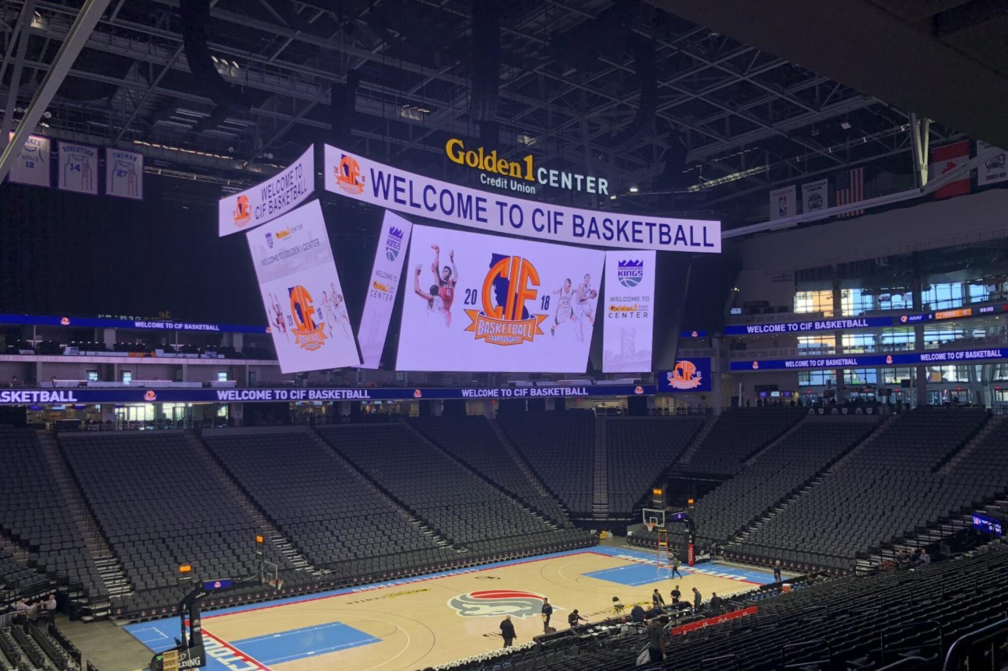 A mostly empty Golden 1 Center in Sacramento with the electronic billboard reading "Welcome to CIF Basketball"