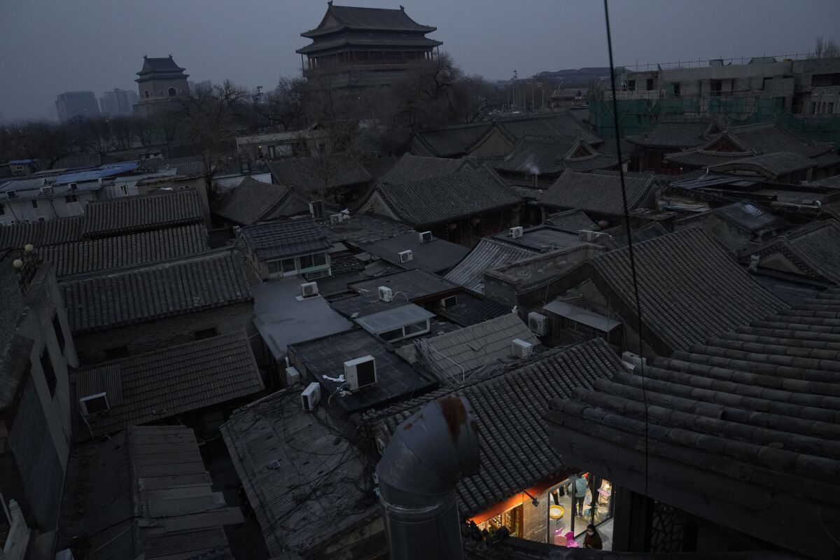 A resident walks past an old district in Beijing, China, Saturday, Nov. 27, 2021. (AP Photo/Ng Han Guan)